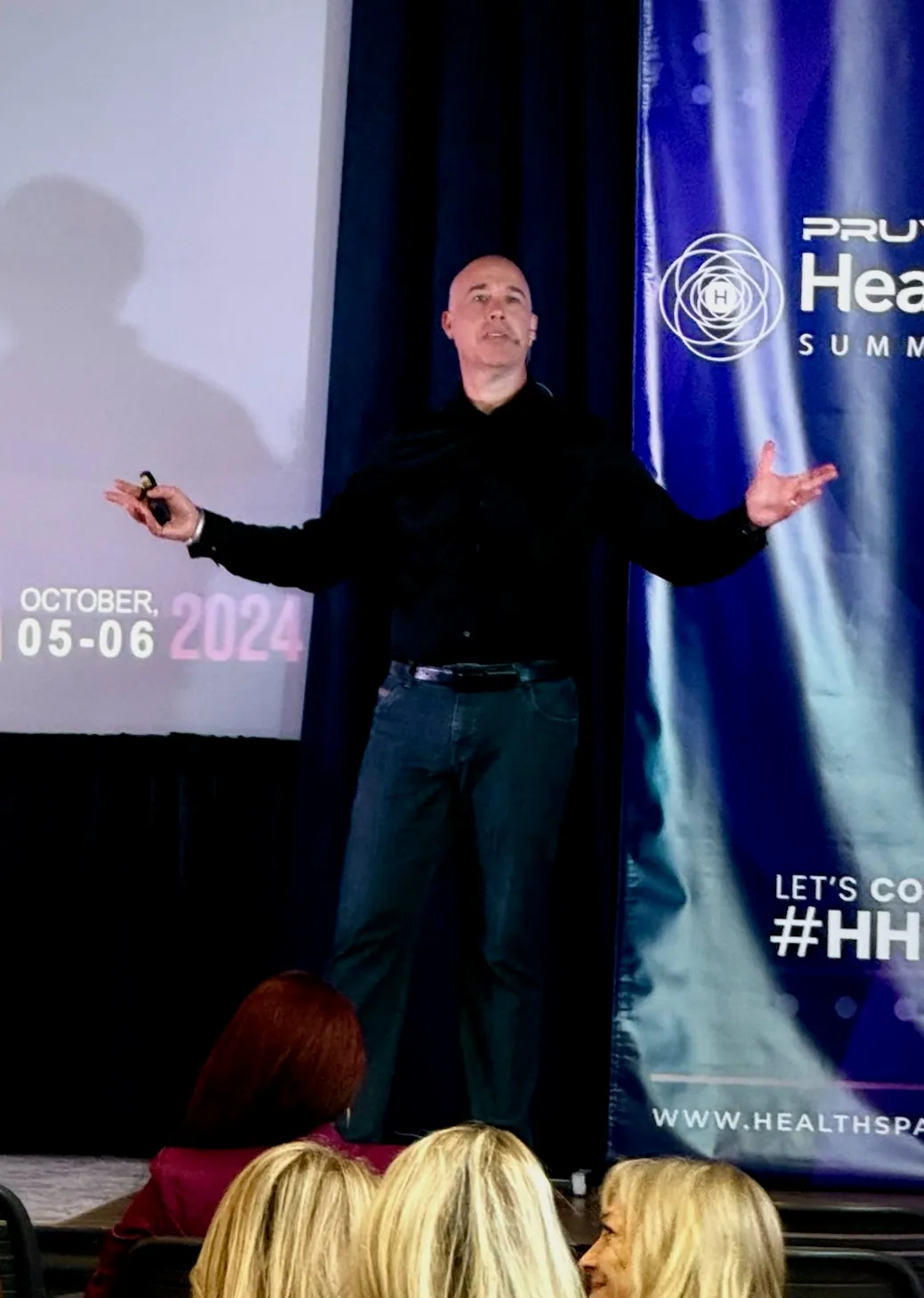 Elias Arjan with arms outstretched on the PRUVN Healthspan Summit stage